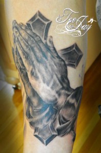Praying hands and cross tattoo