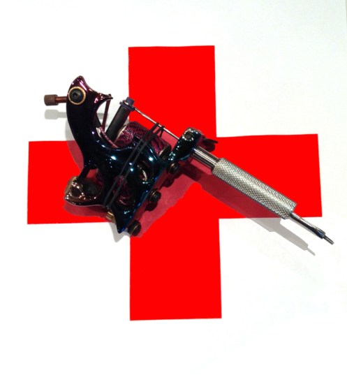 red cross with tattoo machine