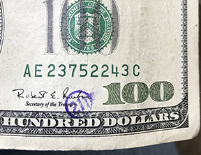 211 stamp in circle on 100 bill